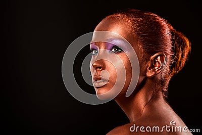 Gilt. Golden Woman's Face Closeup. Futuristic Gilded Make-up. Painted Skin bronze. Stock Photo