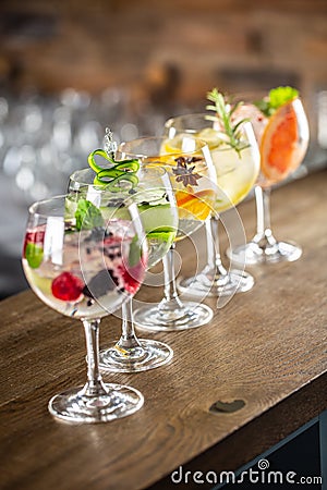 Gin tonic long drink as a classic cocktail in various forms with garnish in individual glasses such as orange, lemon, grapefruit, Stock Photo