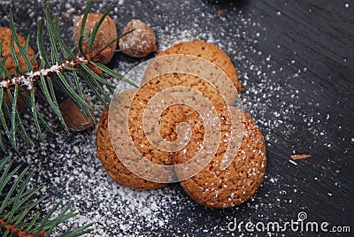 Ginger Christmas cookies on a black board with sugar powder and fir branch. Cooking recipie. Stock Photo