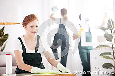 Cleaning lady dusting table Stock Photo