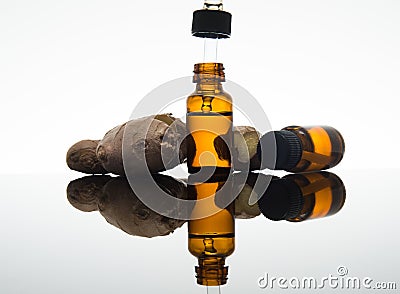 Ginger essential oil in amber bottle with ginger root and dropper Stock Photo