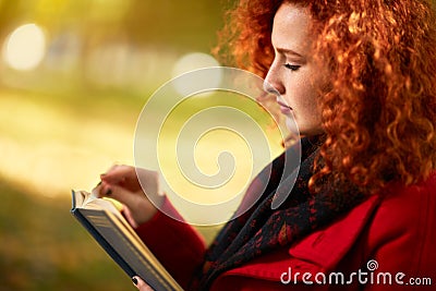 Ginger female reading book Stock Photo