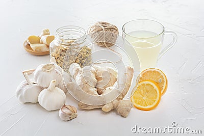 Ginger, garlic, lemon, dried medical chamomile in a jar and ginger tea - a means to protect against viral infections and colds Stock Photo