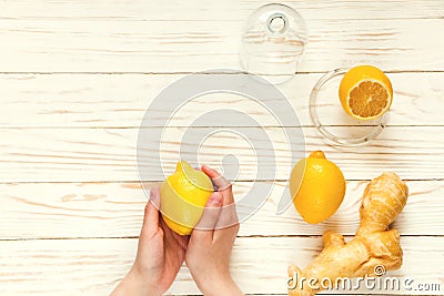 Ginger-lemon in hands on white wooden background, prevention of colds. Selective focus Stock Photo