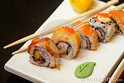 Ginger sushi rolls with decorations served on a white flat tray Stock Photo