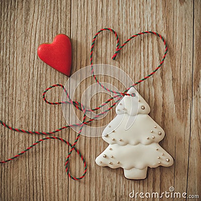 Gingerbread christmas tree hanging over wooden background with heart Stock Photo