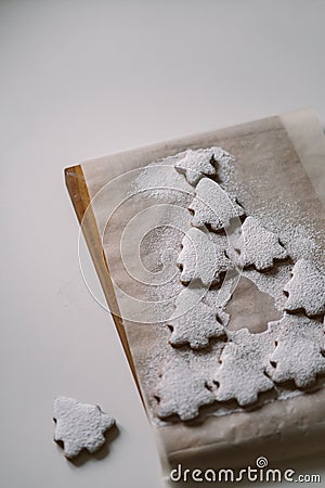 Gingerbread Christmas tree sprinkled with powdered sugar on parchment Stock Photo