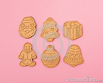 Gingerbread cookie pattern on pastel pink background. Traditional winter biscuit cookies with ornament. Christmas or New Year Stock Photo