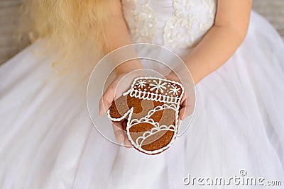 Gingerbread in the girl`s hands in a white magnificent dress Stock Photo