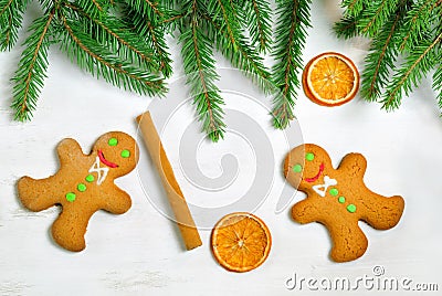 Gingerbread mans and Christmas tree branches on wooden backgroun Stock Photo