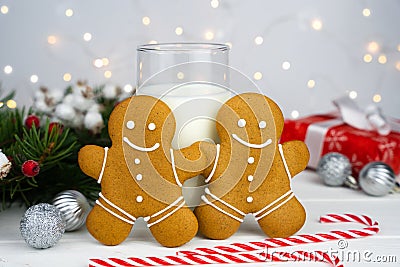 Gingerbread men and glass of milk on the table. Traditional Christmas treat for Santa. Close-up Stock Photo