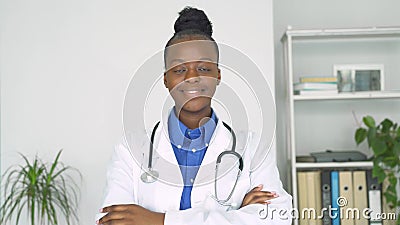 Giovane adulta, donna di colore che sorride, che guarda le braccia incrociate della telecamera. stock footage Giovane adulta, donna di colore che sorride, che guarda le braccia incrociate della telecamera. stock footage