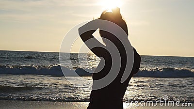 Giovane donna castana che lega coda di cavallo sulla spiaggia vicino al mare al tramonto La bella ragazza schiaccia i suoi capell archivi video Giovane donna castana che lega coda di cavallo sulla spiaggia vicino al mare al tramonto La bella ragazza schiaccia i suoi capell archivi video