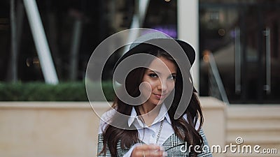 Giovane signora sorridente felice di affari che esamina macchina fotografica fuori mentre lavorando al centro di affari moderno L Giovane signora sorridente felice di affari che esamina macchina fotografica fuori mentre lavorando al centro di affari moderno L