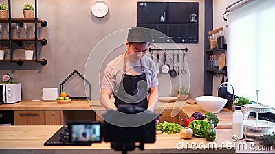 Giovane uomo asiatico in video della registrazione della cucina sulla macchina fotografica Uomo asiatico sorridente che lavora al stock footage Giovane uomo asiatico in video della registrazione della cucina sulla macchina fotografica Uomo asiatico sorridente che lavora al stock footage
