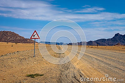 Giraffes crossing warning road sign placed in the desert of Namibia Stock Photo