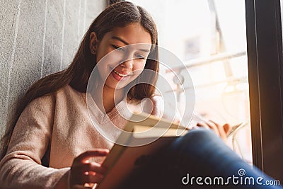 Girl absorbedly reading open book Stock Photo