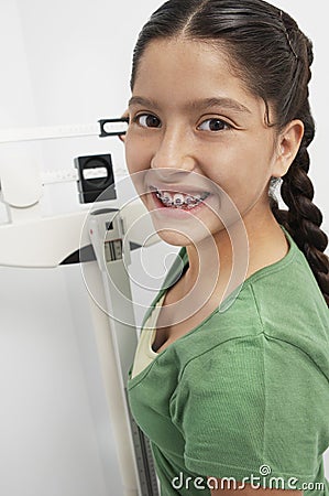 Girl Adjusting Weighing Scale Stock Photo