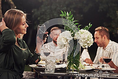 Girl adores flowers. Friends have meeting at evening. Nice outside restaurant Stock Photo