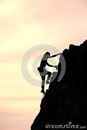 Girl alone conquer the summit during a climb in a fantastic mountain landscape at sunset Stock Photo