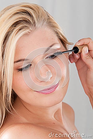 Girl applying black mascara Stock Photo