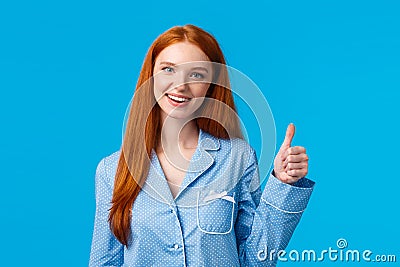 Girl approves recommend product. Cheerful satisfied pretty redhead woman in pyjama, ready sleep, confirm info, showing Stock Photo