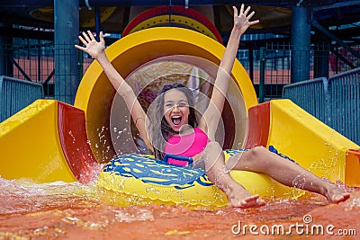 Girl in aqua park have fun riding on water slide with inflatable ring Stock Photo