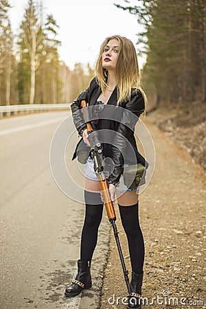 Girl assassin waiting for his victim on the road. Stock Photo