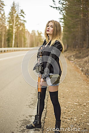 Girl assassin waiting for his victim on the road. Stock Photo