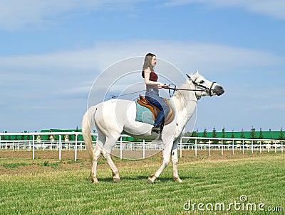 Girl astride a horse on a hippodrome Stock Photo