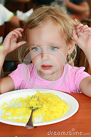 The girl ate the rice and no longer wants. Stock Photo