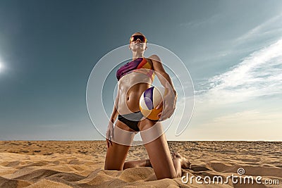 Girl athlete volleyball player on the beach playing at sunset Stock Photo