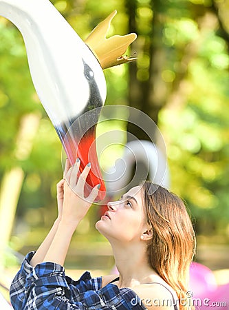 Girl with attentive face looks up. Woman and swan Stock Photo