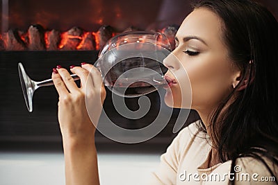Girl attractive woman makeup face drinking wine wineglass background fireplace background. Luxury wine. Enjoy noble Stock Photo