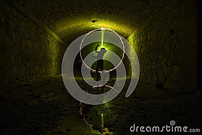 Girl backlight circle fire in tunnel. light painting Stock Photo