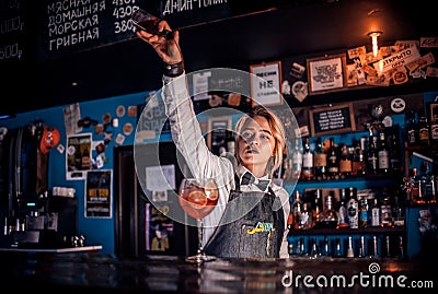 Girl barman mixes a cocktail in the bar Stock Photo