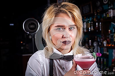 Girl barman concocts a cocktail behind the bar Stock Photo