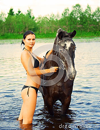 Girl bathe horse in a river Stock Photo