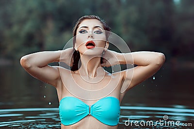 Girl in a bathing suit emerged from the water. Stock Photo