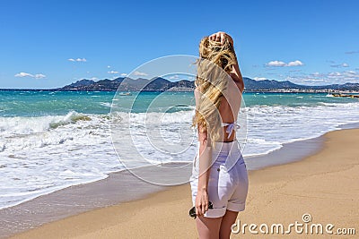 Girl at the beach in Cannes, France. Beautiful Seaside background. Back view Stock Photo