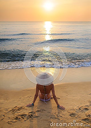 girl on beach at sunset wearing rice hat 3 Stock Photo