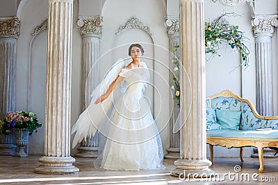 A girl in a beautiful dress and white wings of an angel inspires Stock Photo