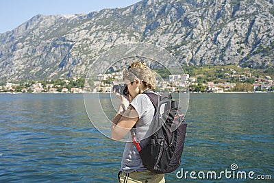 Girl from behind photographing on the seafront promenade Stock Photo