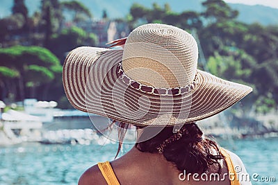 Girl from behind with straw hat on her head. Woman explorer traveler. Blurred background Stock Photo