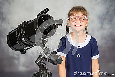 Girl bespectacled amateur astronomer funny smiling standing by telescope Stock Photo