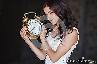 The girl with a big clock on a dark background Stock Photo