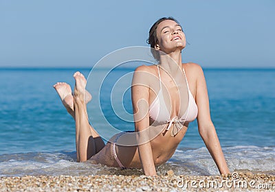 Girl in bikini lying bent back with eyes closed outdoors Stock Photo