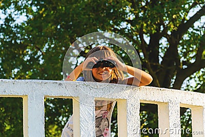 Girl with binoculars on the lookout Stock Photo