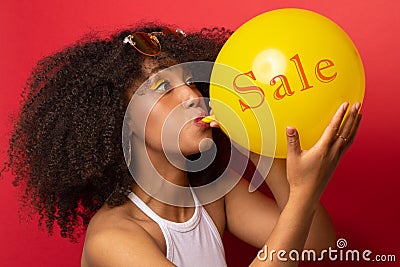 Girl inflates the ball with the inscription sales Stock Photo