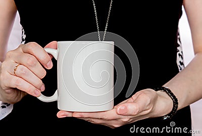 Girl in black dress is holding white cup in hands. Stock Photo